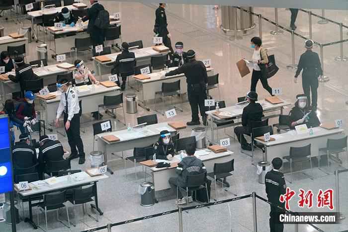 资料图:4月7日,工作人员在香港国际机场禁区为入境者办理居家检疫手续,并为入境者佩戴用于居家检疫监察的蓝牙电子手环。 中新社记者 张炜 摄 香港特区政府:无病征抵港者病毒检测安排加强